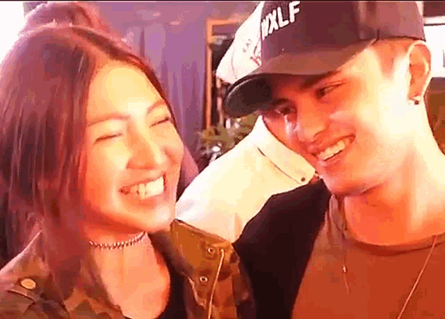a man and a woman are looking at each other and smiling .