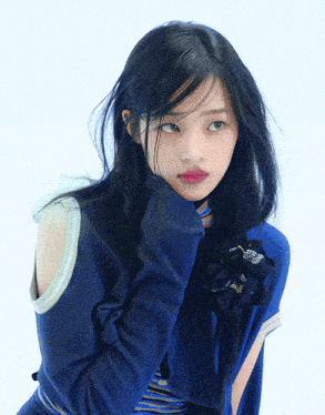 a woman wearing a blue sweater with a flower on her neck
