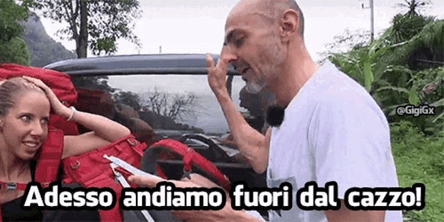 a man wipes his nose while a woman holds her head and the words adesso andiamo fuori dal cazzo