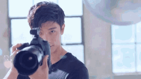 a young man is taking a picture with a camera in a room .