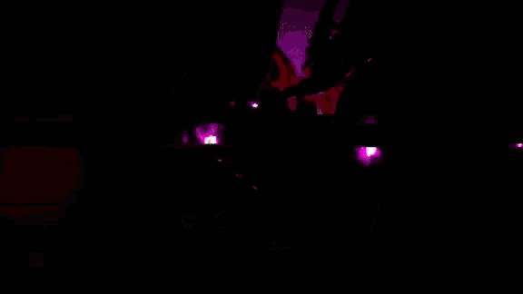a purple and green circle with a white circle in the middle on a black background .