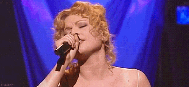 a close up of a woman singing into a microphone with android25 written on the bottom