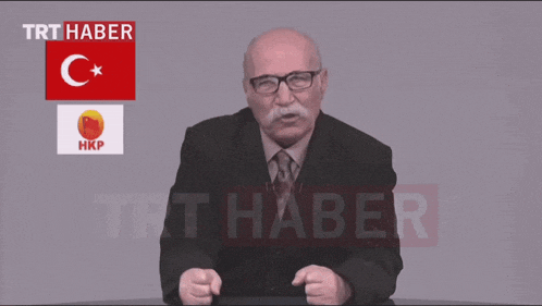 a man in a suit and tie is speaking in front of a trt haber logo