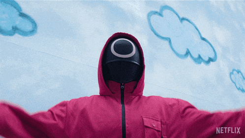 a person wearing a pink jacket with a hood and a black mask with a circle on it