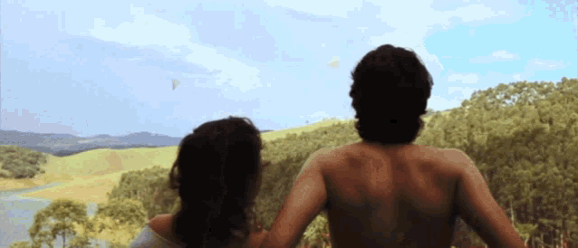 a man and woman looking out over a lake