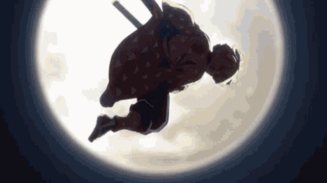 a silhouette of a person flying through the air with a full moon in the background