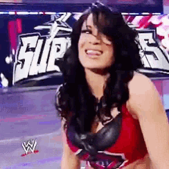 a woman is smiling in front of a sign that says ' super '