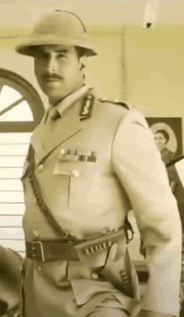 a man in a military uniform is wearing a helmet and holding a gun .