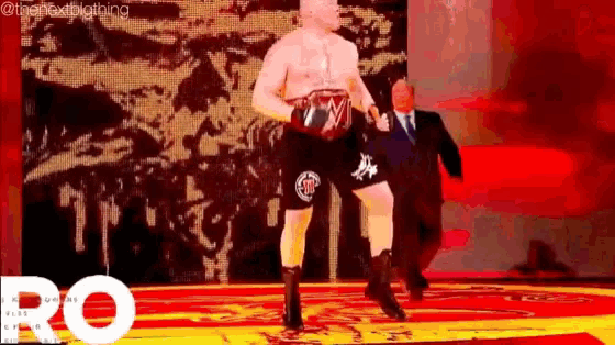 a man without a shirt is standing on a stage in a boxing ring .