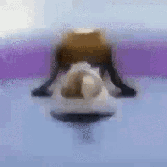 a blurry picture of a person laying on a purple surface .