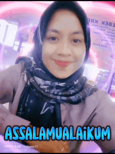 a woman wearing a hijab and a scarf is smiling with the words assalamualaikum written in blue