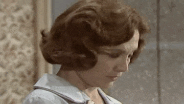 a close up of a woman 's face with her eyes closed and her hair blowing in the wind .