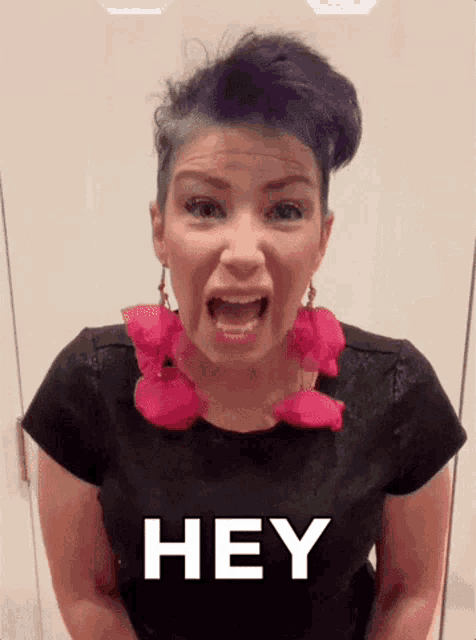 a woman with purple hair is wearing a black shirt with the word hey on it