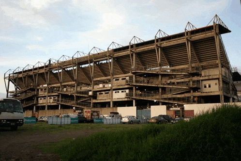 a stadium with a lot of cars parked in front