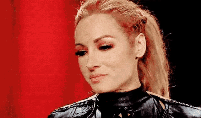 a close up of a woman 's face with a red background and a ponytail .