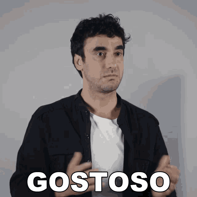a man in a black shirt is making a gesture with the word gostoso in white letters