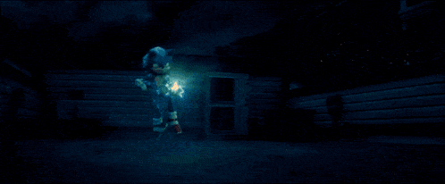 a person is standing in a dark room with the sun shining through the window .