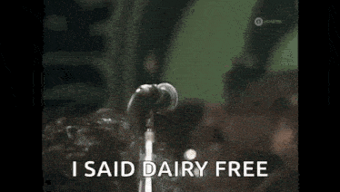 a man singing into a microphone with the words `` i said dairy free '' written on the screen .