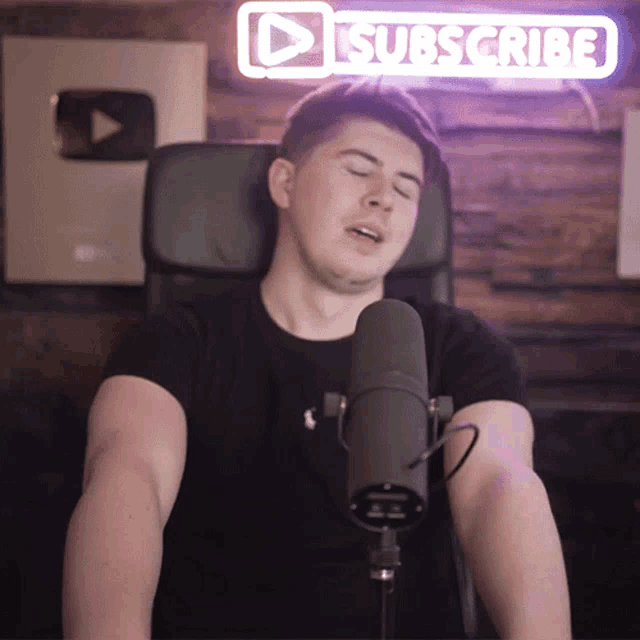 a man is singing into a microphone with a subscribe sign in the background