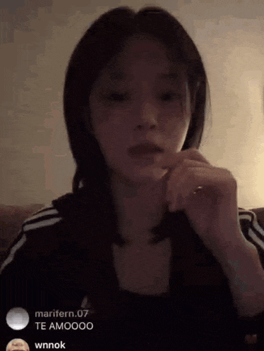 a young woman is sitting on a couch in a dark room .