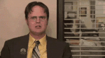 a man in a suit and tie is making a face in front of a window .