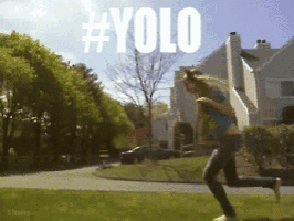 a girl is running in a park with the word yolo written on the bottom