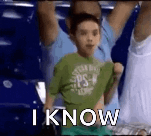 a young boy in a green shirt says i know in a crowd of people .