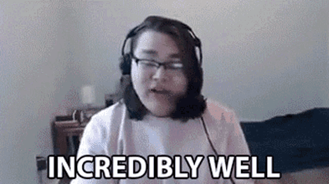 a woman wearing headphones and glasses is sitting in front of a computer screen .