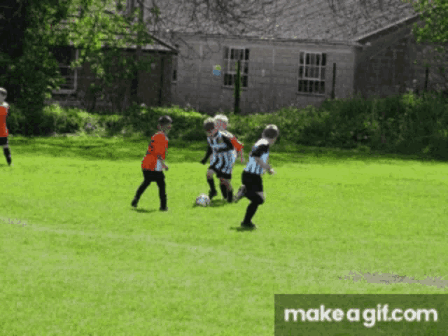a group of young boys are playing soccer on a lush green field with the words make a gif.com at the bottom