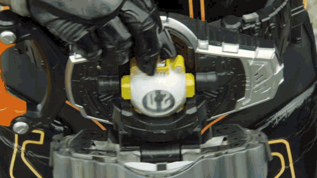 a close up of a toy with a yellow and white object with a s on it