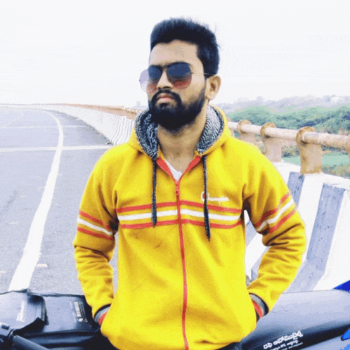 a man wearing sunglasses and a yellow champion hoodie