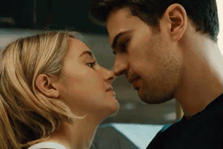 a man and a woman are kissing each other in a room .
