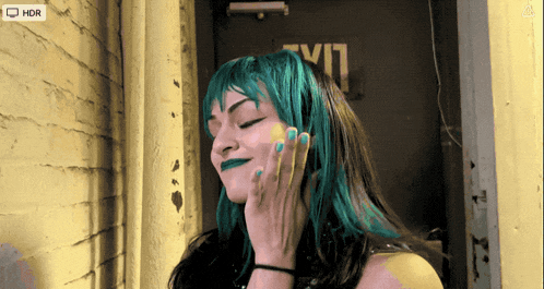 a woman with blue hair stands in front of a door that says exit