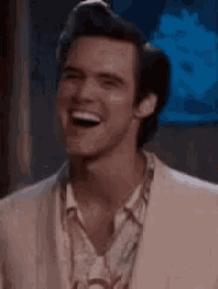 a man in a suit and shirt is laughing and smiling .