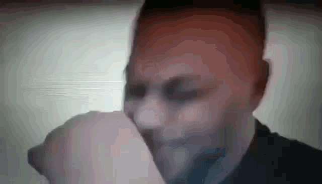 a close up of a man 's face with his hand on his mouth .