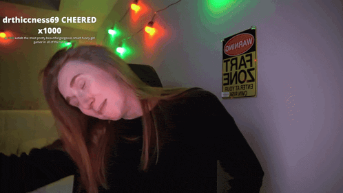 a woman with her eyes closed stands in front of a sign that says drthicness69 cheered