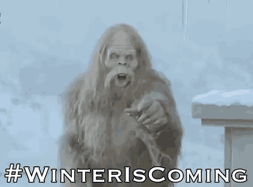 a bigfoot with a beard and long hair is standing in the snow holding a bird .