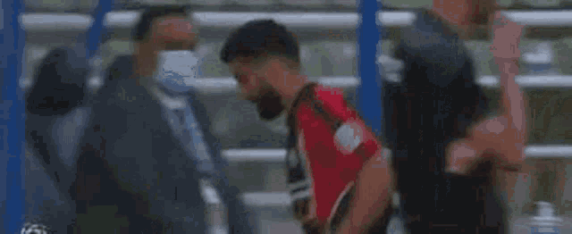 a man with a beard is walking on a treadmill in a gym .