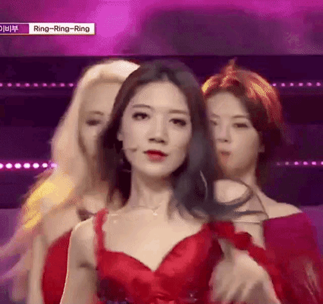 a woman in a red dress is standing on a stage .