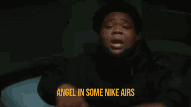 a man is pointing at the camera with the words angel in some nike airs behind him
