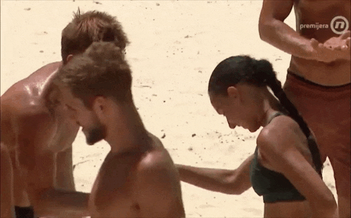 a woman in a bikini is touching a man 's chest in front of a sign that says premijera