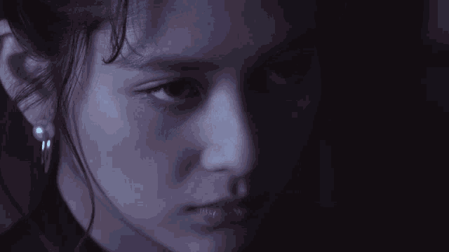 a close up of a girl 's face with a dark background
