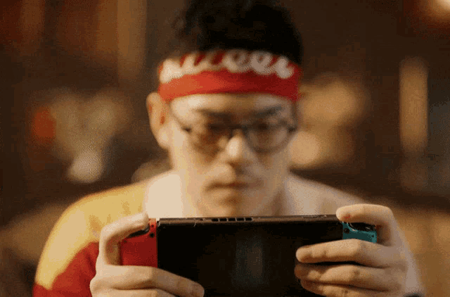 a man wearing glasses and a red headband with the word " cool " on it