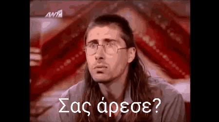 a man with long hair and glasses is wearing a mullet and a ponytail .
