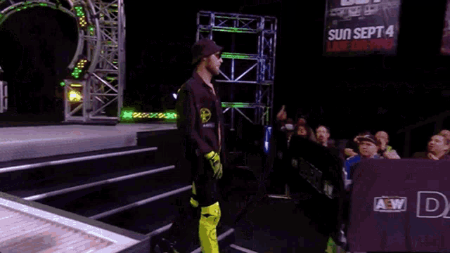 a man in a wrestling ring with a sign that says " all out " on it