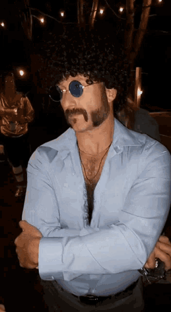 a man with a beard and mustache wearing sunglasses and a blue shirt