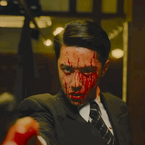 a man in a suit with blood on his face