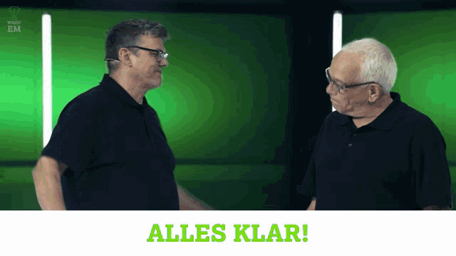 two men are talking in front of a green screen with the words alles klar