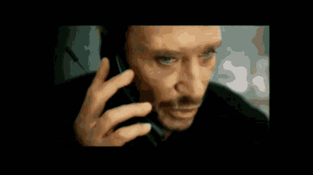 a man is talking on a cell phone in a dark room .