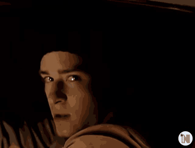 a close up of a man 's face with the letter n in the upper right corner